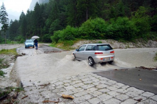 Samochód przekraczający zalany odcinek drogi